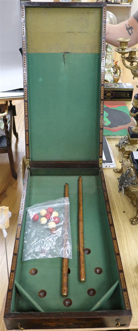 A table-top billiards/bagatelle board, complete with ivory balls and cues. overall length 123cm width 31cm